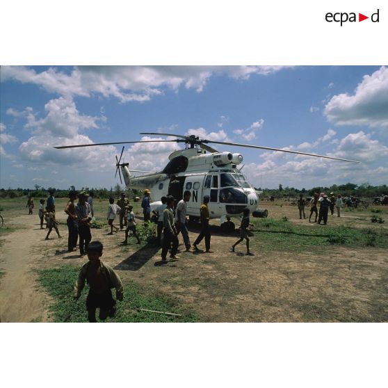 Hélicoptère Puma SA 330 aux couleurs de l'ONU au sol au poste frontière CV2 entre Cambodge et Vietnam, entouré de la population civile.