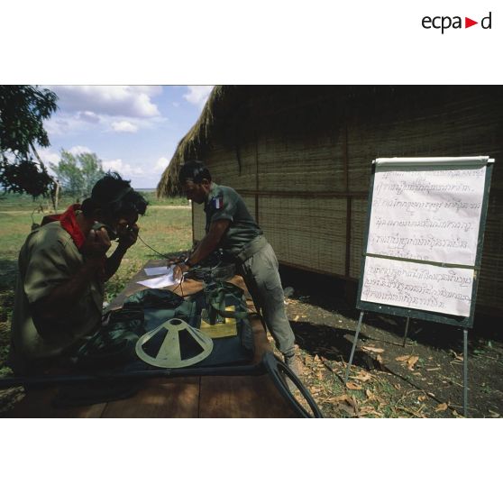 Apprentissage du déminage à l'aide d'un détecteur de mines dit poêle à frire par un élève cambodgien encadré par un casque bleu.