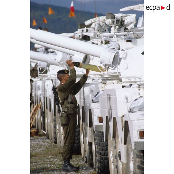 Marsouin du 1er régiment d'infanterie de marine (1er Rima) chargeant un obus 90 mm dans l'un des véhicules blindé à roues ERC-90 Sagaie rassemblés.