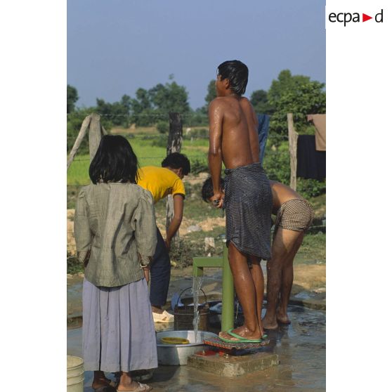 Des cambodgiens utilisent la pompe à eau d'un village de réfugiés près de Siem Reap.