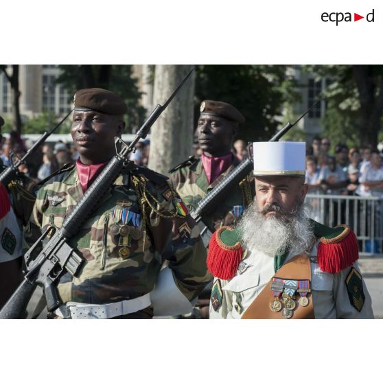 Un pionnier de la Légion étrangère défile aux côtés des tirailleurs sénégalais sur les Champs-Elysées à Paris.