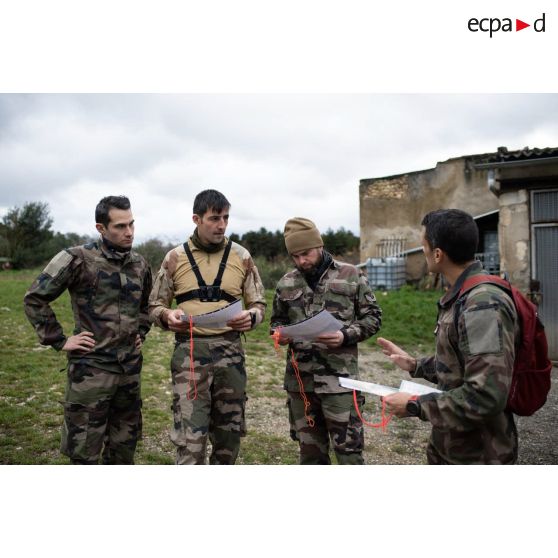 Un instructeur du 8e régiment parachutiste d'infanterie de marine (RPIMa) brieffe une équipe image pour une course d'orientation sur le camp de Causse.