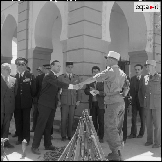 Aïn Sefra. Le colonel Tevenot présente à Michel Debré et à sa suite l'armement récupéré lors de l'opération du djebel Bou Hamoud.