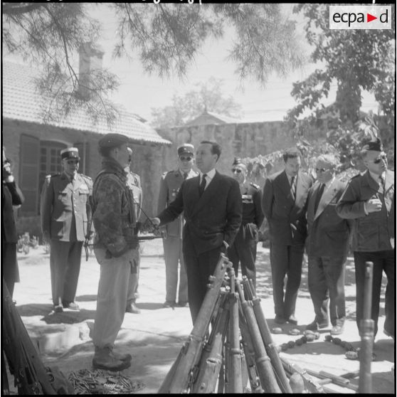 Aïn Sefra. Le colonel Tevenot présente à Michel Debré et à sa suite l'armement récupéré lors de l'opération du djebel Bou Hamoud.