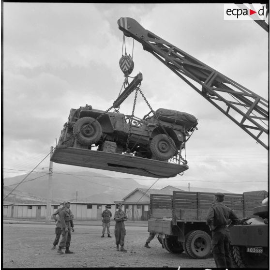 Parachutistes du centre de Blida. Chargement d'une jeep dans un camion.