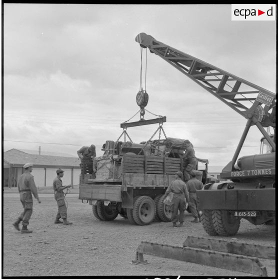 Parachutistes du centre de Blida. Chargement d'une jeep dans un camion.