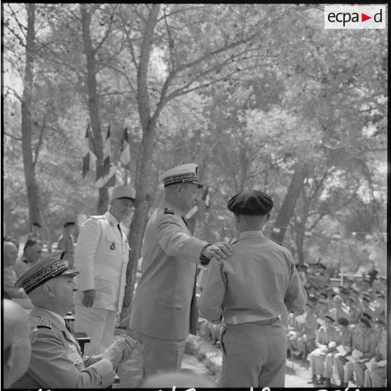 Le général d'armée aérienne Challe, commandant en chef des Forces armées en Algérie, félicite un élève qui vient de recevoir le grand prix d'honneur offert par le ministre des Armées, à l'occasion de la cérémonie de distribution solennelle des prix de l'Ecole militaire préparatoire nord-africaine (EMPNA) de Koléa, sous le regard du lieutenant-colonel Rouvière, commandant de l'Ecole.