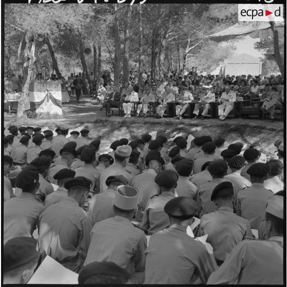 M. Hocq, professeur de lettres, prononce le discours d'usage, sous le regard du général d'armée aérienne Challe, commandant en chef des Forces en Algérie, du lieutenant-colonel Roudière, commandant de l'Ecole militaire préparatoire nord-africaine (EMPNA) de Koléa, de personnalités civiles, militaires et des élèves, à l'occasion de la cérémonie de distribution solennelle des prix dans les jardins de l'Ecole.