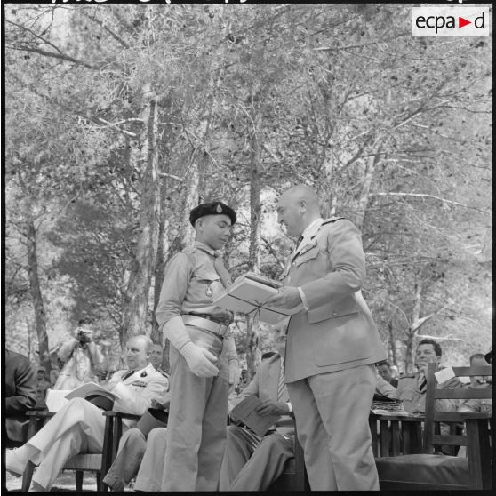 Le colonel Lehir, commandant du 2e régiment de parachutistes coloniaux (2e RPC), remet un prix d'excellence à un élève dans les jardins de l'Ecole militaire préparatoire nord africaine (EMPNA) de Koléa.