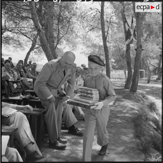 Le colonel Lehir, commandant du 2e régiment de parachutistes coloniaux (2e RPC), remet un prix d'excellence à un élève dans les jardins de l'Ecole militaire préparatoire nord africaine (EMPNA) de Koléa, sous le regard d'autorités militaires.