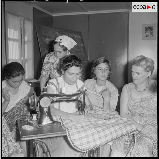 Au Cercle féminin d'Affreville, une jeune fille apprend à coudre à la machine, sous le regard de l'animatrice.