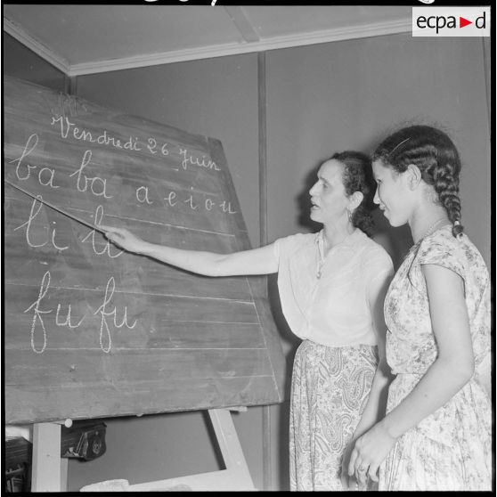 Une éducatrice du Cercle féminin d'Affreville apprend à lire à une jeune femme.