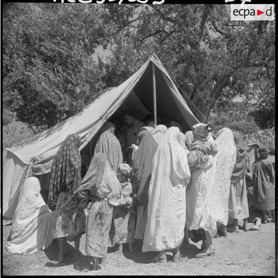 Devant la tente de l'antenne médicale au poste de Bou Maad, des femmes et des enfants attendent leur tour pour passer devant le médecin.