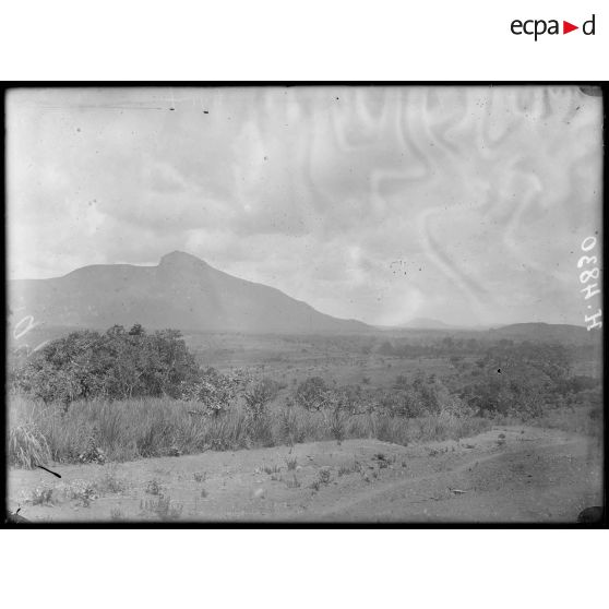 Route de Bana à Foumban. Entre Baïgam et Kouti, aspect général de la région : plaine et monts Bapit. [légende d'origine]