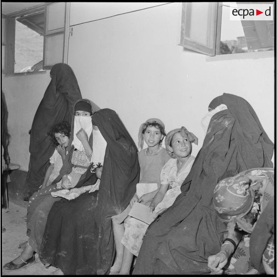 Des femmes et des jeunes filles attendent assises à l'intérieur d'une antenne médicale.