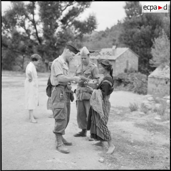 A l'occasion de sa visite dans le village de Ait-Ayaya, une femme offre quelques figues au capitaine du 5e bureau et à un officier.