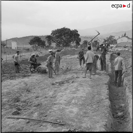 Les enfants du centre de regroupement de Taliouine, situé dans dans la vallée de l'Oued Isser, participent à l'édification de leur école.