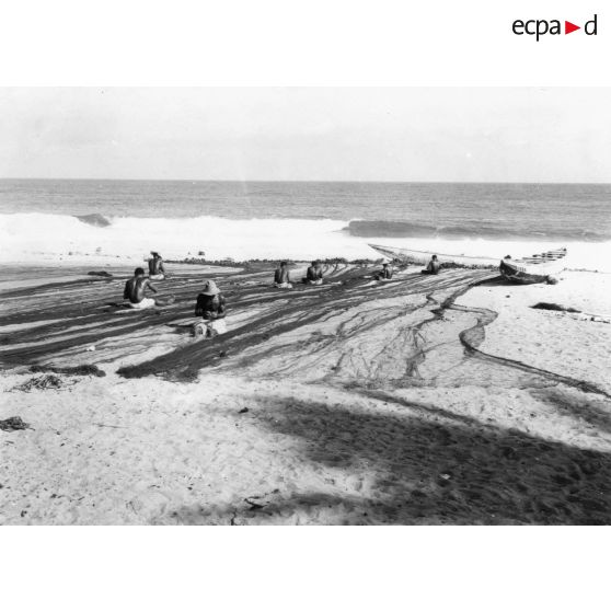 République de Côte d'Ivoire, Vridi, 1965. Pêcheurs réparant leurs filets.