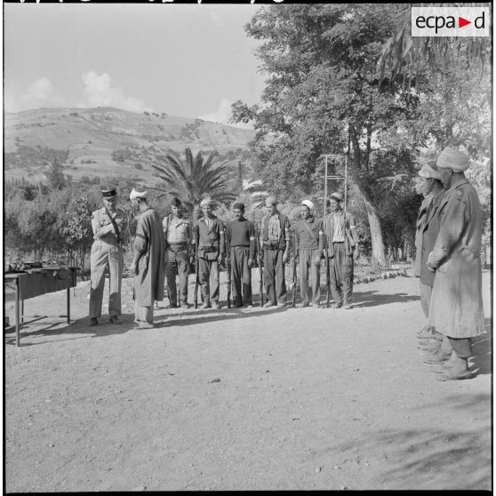 Le capitaine Moreau, commandant de la 3e compagnie du 1er régiment d'infanterie de marine (1er RIMa), remet des armes aux membres du groupe d'auto-défense de Taliouine, situé dans la vallée de l'Oued Isser (région de Palestro).