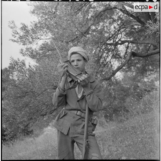 Portrait d'un jeune membre du groupe d'auto-défense de Taliouine, située dans la région de Palestro, en liaison radio avec le poste de commandement de la 3e compagnie du 1er régiment d'infanterie de marine (1er RIMa), en pleine montagne.