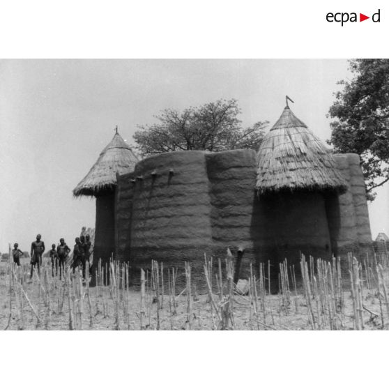 République togolaise, 1953. Case Tamberma dans la région de Nadobe. Au premier plan : chaumes de mil.