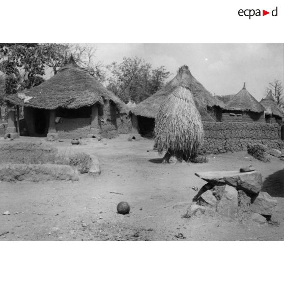 République togolaise, village de Pallakoko, 1954. Au 1er plan, à droite, la pierre qui sert à écraser les graines.