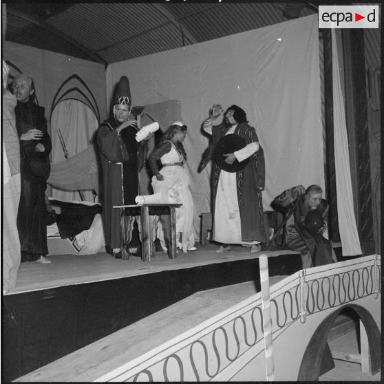 Un groupe de comédiens sur scène à l'occasion de la répétition générale de la comédie Volpone, du dramaturge anglais Ben Johnson, devant des officiers, sous-officiers et hommes de troupe de la 428e Compagnie de réparation divisionnaire (428e CRD).