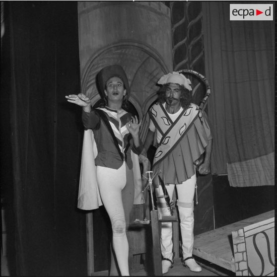 Portrait de deux comédiens sur scène à l'occasion de la répétition générale de la comédie Volpone, du dramaturge anglais Ben Johnson, devant des officiers, sous-officiers et hommes de troupe de la 428e Compagnie de réparation divisionnaire (428e CRD).