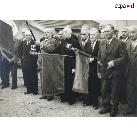 74. Remise de la légion d'honneur à M. l'Abbé Loys Roux par son frère chevalier le 28 août 1960 au monument aux morts des deux guerres à Chénas Rhône. [légende d'origine]