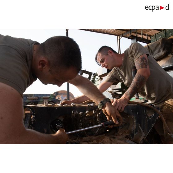 Des mécaniciens interviennent sur une pièce mécanique d'un véhicule de l'avant blindé (VAB) à l'atelier de maintenance de Gao, au Mali.