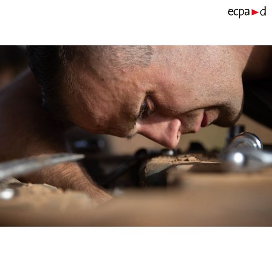 Un mécanicien intervient sur une pièce mécanique d'un véhicule de l'avant blindé (VAB) à l'atelier de maintenance de Gao, au Mali.