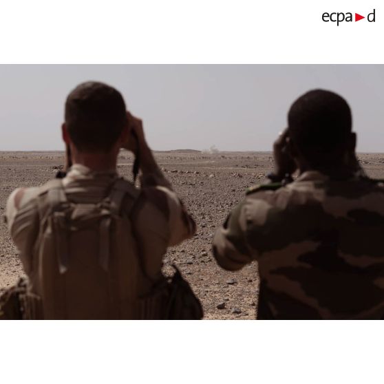 Un soldat malien observe une zone de tir sous la supervision d'un artilleur du 93e régiment d'artillerie de montagne (RAM) à Tessalit, au Mali.