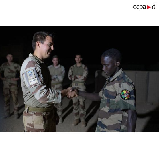 Un guideur aérien tactique avancé (GATA) remet une diplôme à un soldat malien au terme d'une formation au contrôle aérien à Tessalit, au Mali.