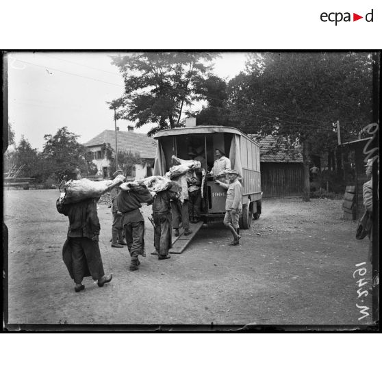 Abattoir militaire de Fellering, transport à dos d'hommes de quartiers de boeufs abattus et mis en autobus. [légende d'origine]