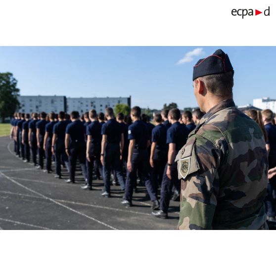 Des élèves marchent en ordre serré sous le regard d'un cadre au Prytanée National Militaire de La Flèche.