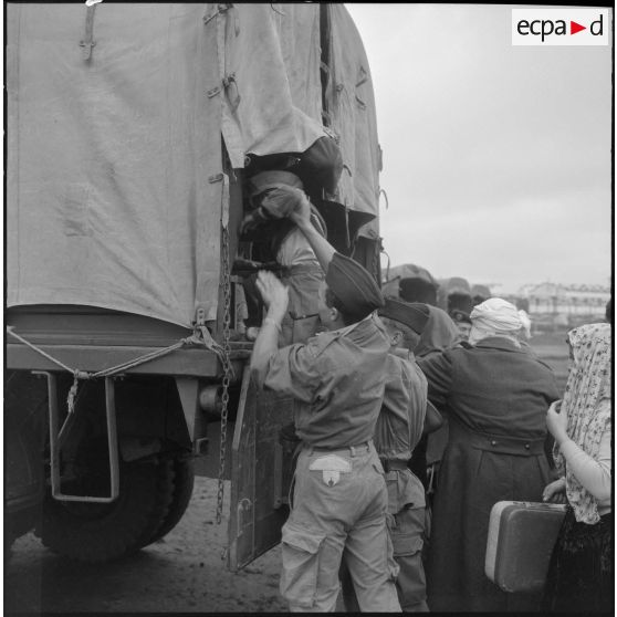 Famille de harki partant pour la France aidée par les soldats du 26e régiment d'infanterie motorisé (RIM).