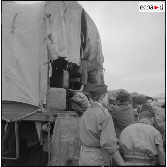 Famille de harki partant pour la France aidée par les soldats du 26e régiment d'infanterie motorisé (RIM).