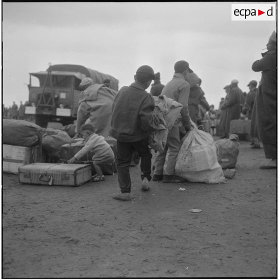 Familles de harkis partant pour la France aidées par les soldats du 26e régiment d'infanterie motorisé (RIM).