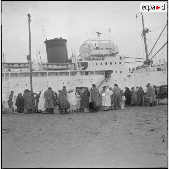 Harkis et leurs familles attendant au port de Bône l'embarquement pour la France à bord du paquebot Pumier.