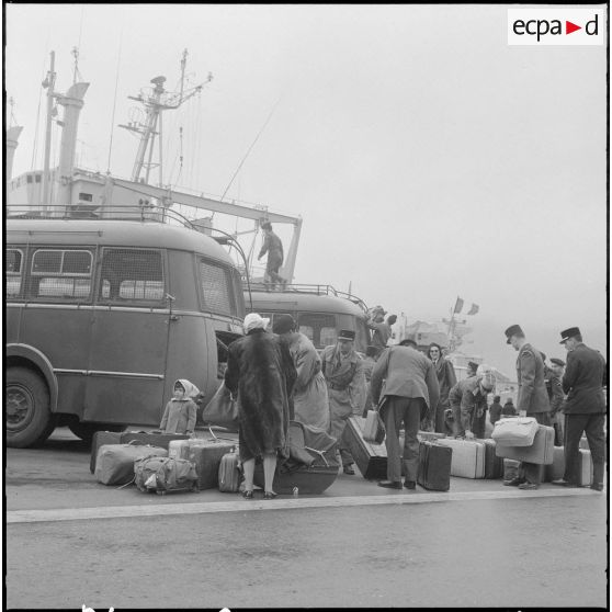 Familles partant du port d'Oran pour la France, aidées par des soldats.