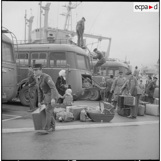 Femmes et enfants partant du port d'Oran pour la France, aidés par des soldats.