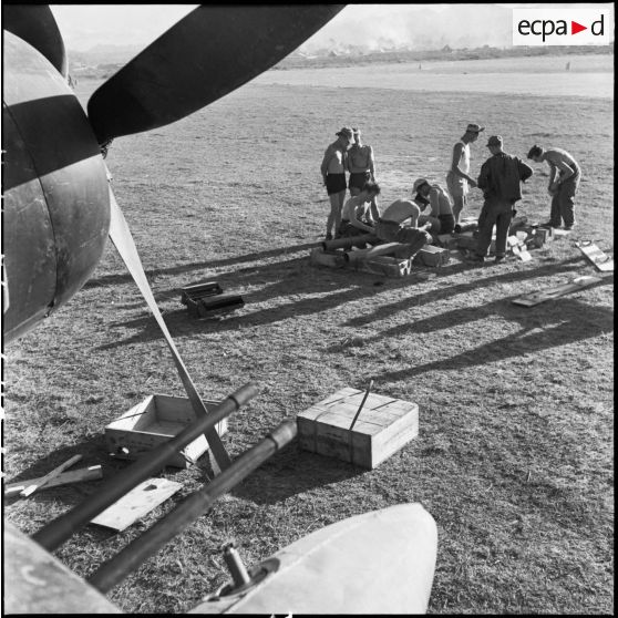 Des armuriers préparent des roquettes pour les avions de chasse Bearcat F8F du groupe de chasse 1/22 Saintonge présents sur le terrain d'aviation de Diên Biên Phu.