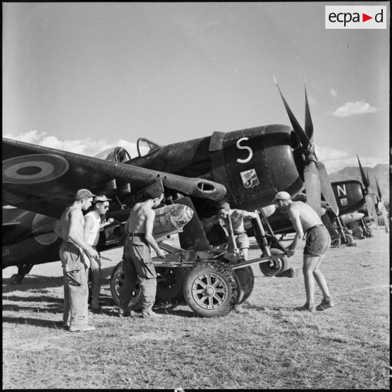 Des armuriers chargent une bombe de 500 livres sur un avion de chasse Bearcat avant son départ en mission sur le terrain de Diên Biên phu.