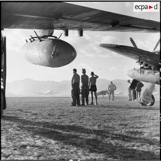 Des mécaniciens du groupe de chasse 1/22 Saintonge observent quelques-uns des neuf Bearcat décoller pour une mission de bombardement sur la route provinciale 41.