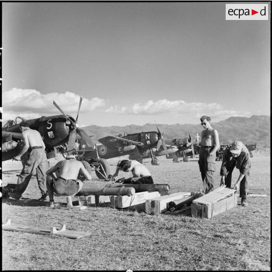 Des armuriers préparent des roquettes pour les avions de chasse Bearcat F8F du groupe de chasse 1/22 Saintonge présents sur le terrain d'aviation de Diên Biên Phu.