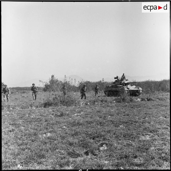 Patrouille de l'infanterie avec l'appui de blindés du 3e régiment de marche du 1er régiment de chasseurs à cheval (RCC) au cours d'une offensive contre des positions de l'Armée populaire vietnamienne à Diên Biên Phu.