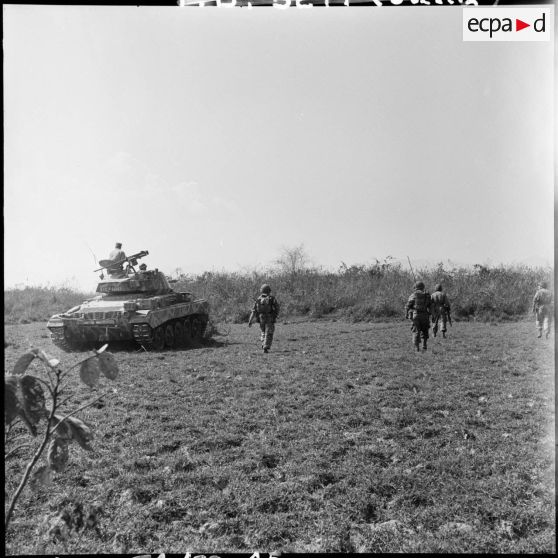 Patrouille de l'infanterie avec l'appui de blindés du 3e régiment de marche du 1er régiment de chasseurs à cheval (RCC) au cours d'une offensive contre des positions de l'Armée populaire vietnamienne à Diên Biên Phu.