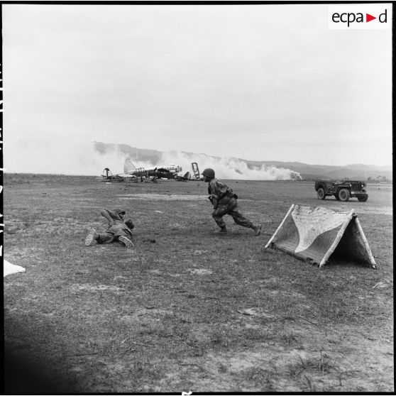 Le photographe Jean Péraud et le caméraman Pierre Schoendoerffer en action près du terrain d’aviation de Diên Biên Phu pendant des tirs de l’artillerie vietminh.