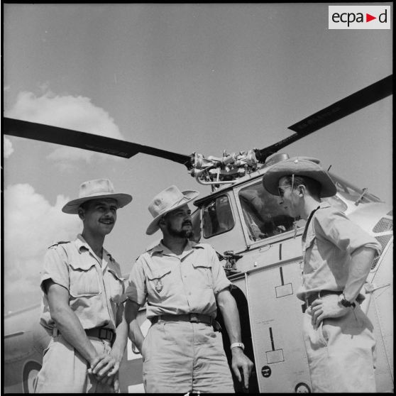 Des officiers devant un hélicoptère Sikorsky H-19 sur le camp de Muong Sai.