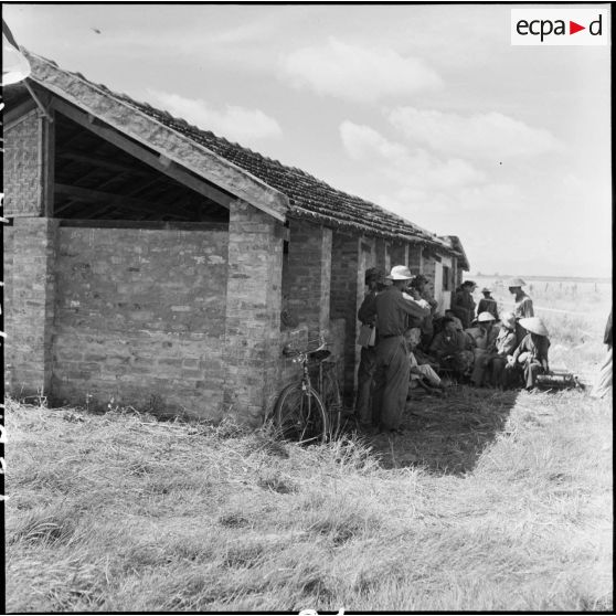 Un groupe de cadres et de prisonniers vietminh attend près d'un baraquement au cours d'un échange de prisonniers à Viet Tri.